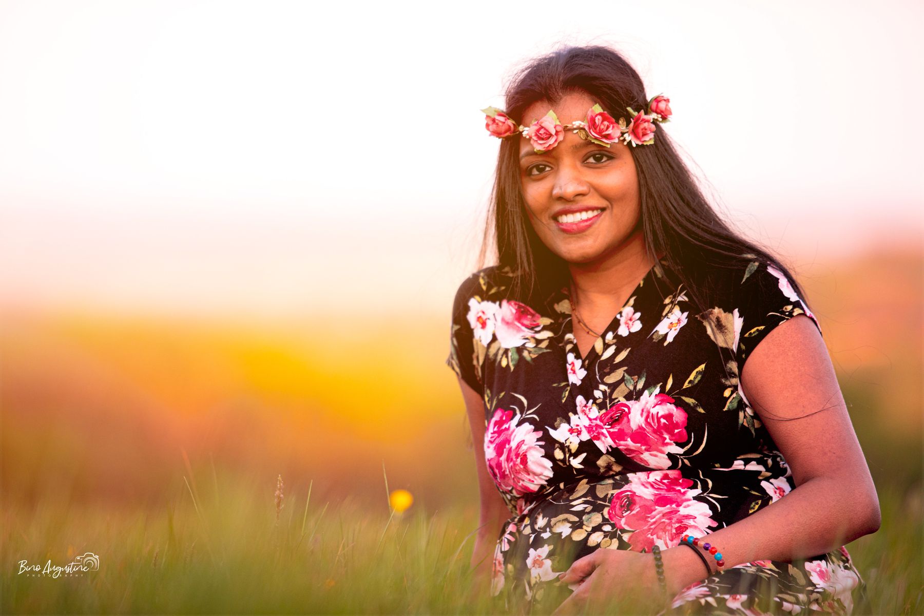 Mother-to-be wearing a flower crown at sunset